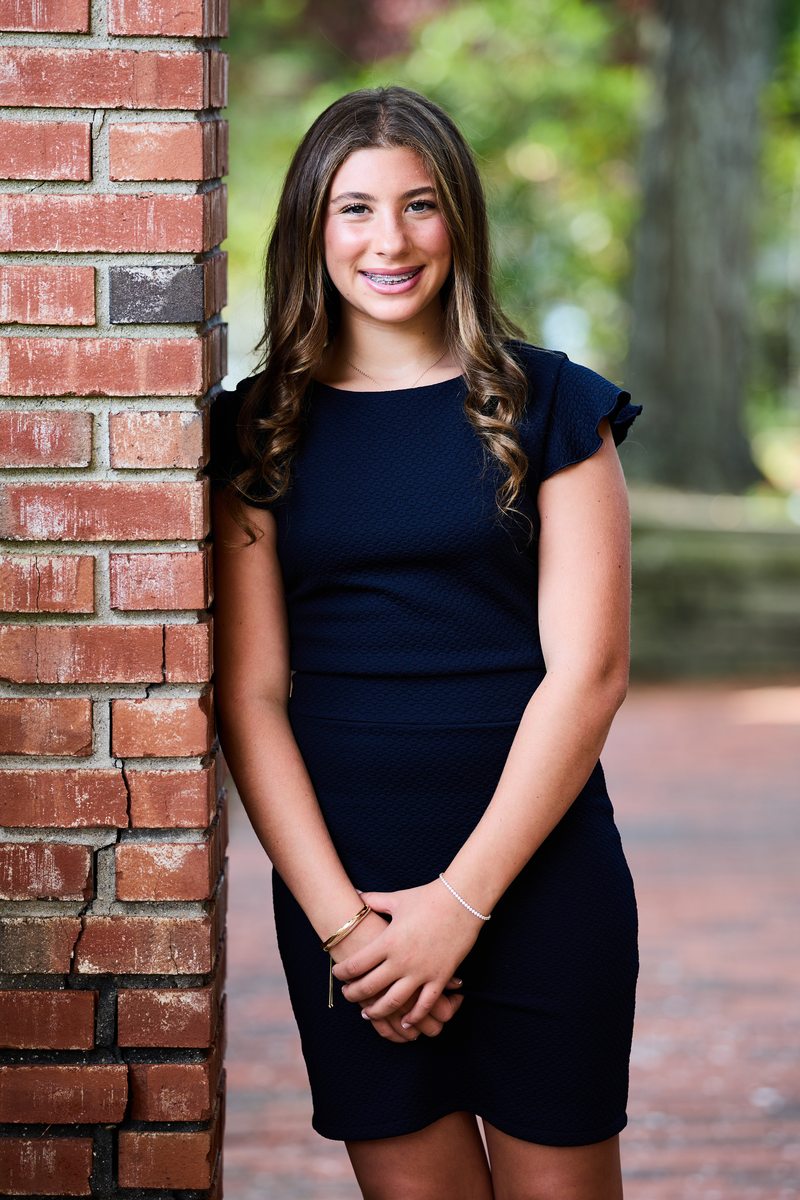 Bat mitzvah portrait against brick wall
