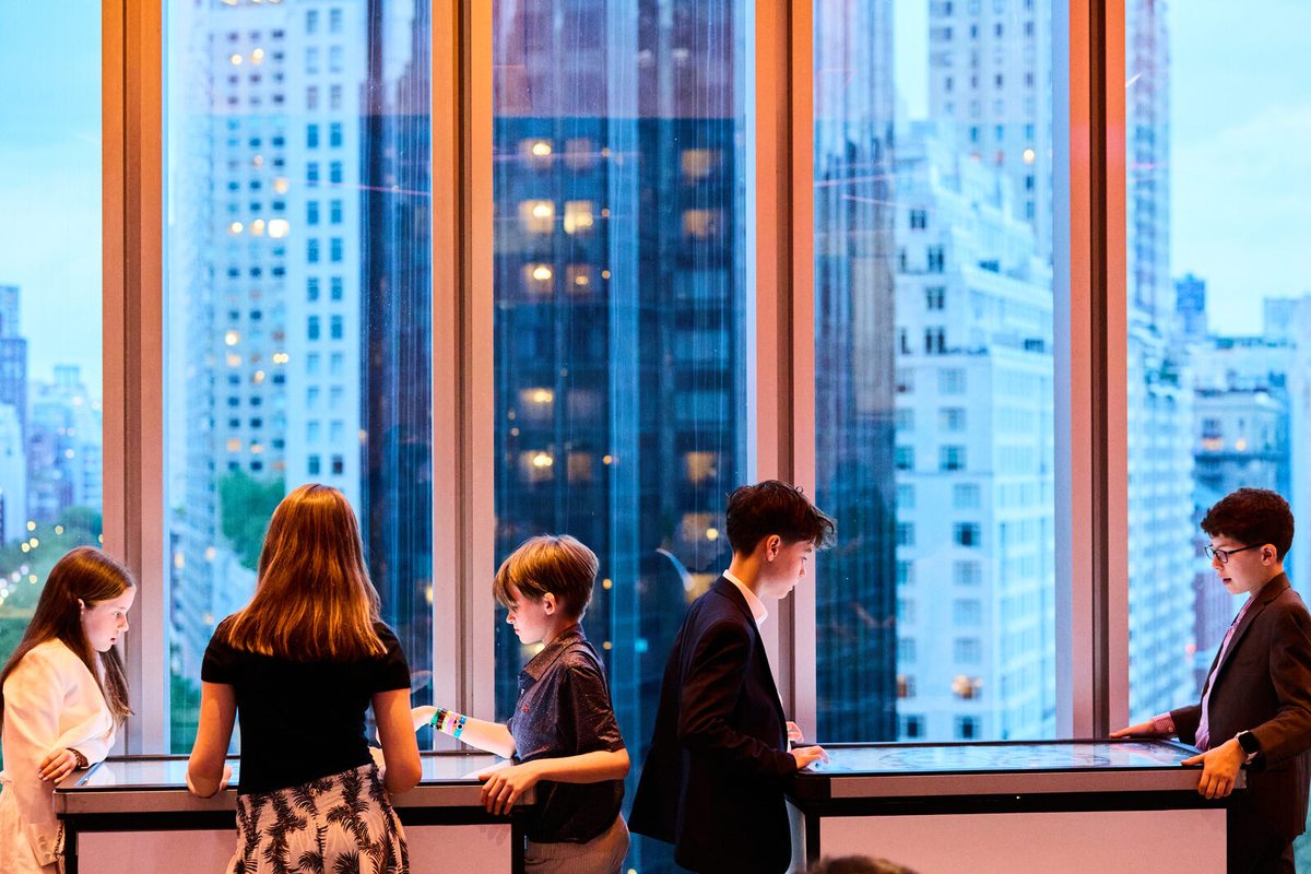 Mitzvah guests with NYC skyline at dusk