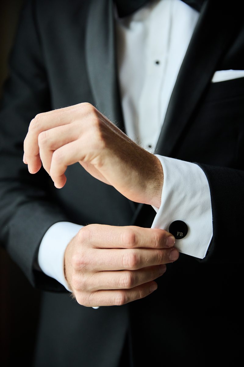 Groom fastening cufflinks detail shot