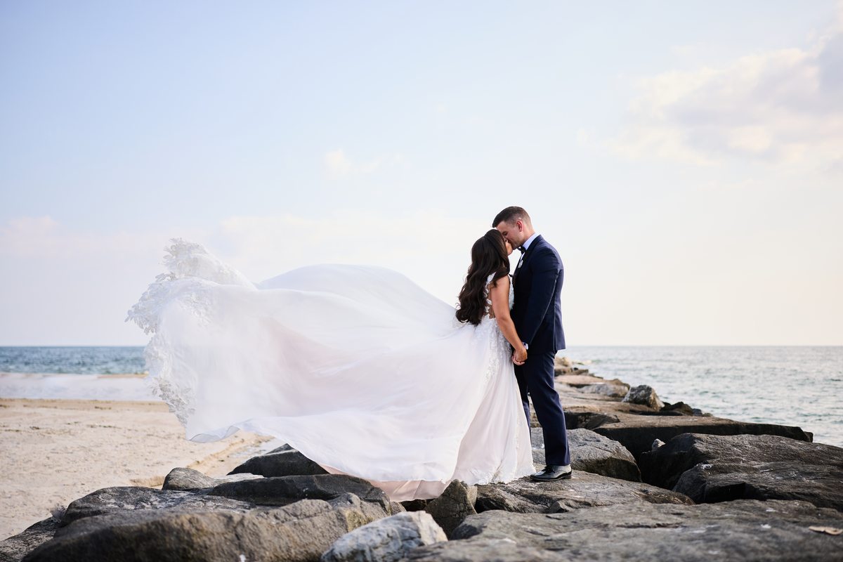 Wedding dress blowing in the wind by the ocean