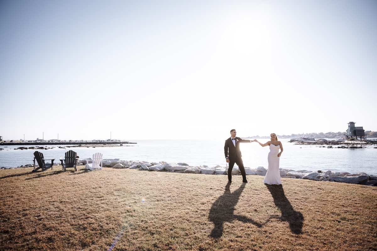 Couple dancing by the waterfront at golden hour